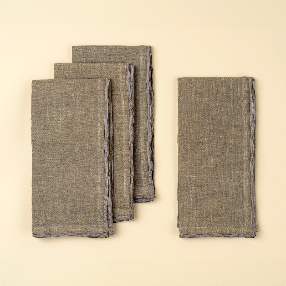 Lot de 4 serviettes en lin lavé gris rectangulaires, pliées en pile