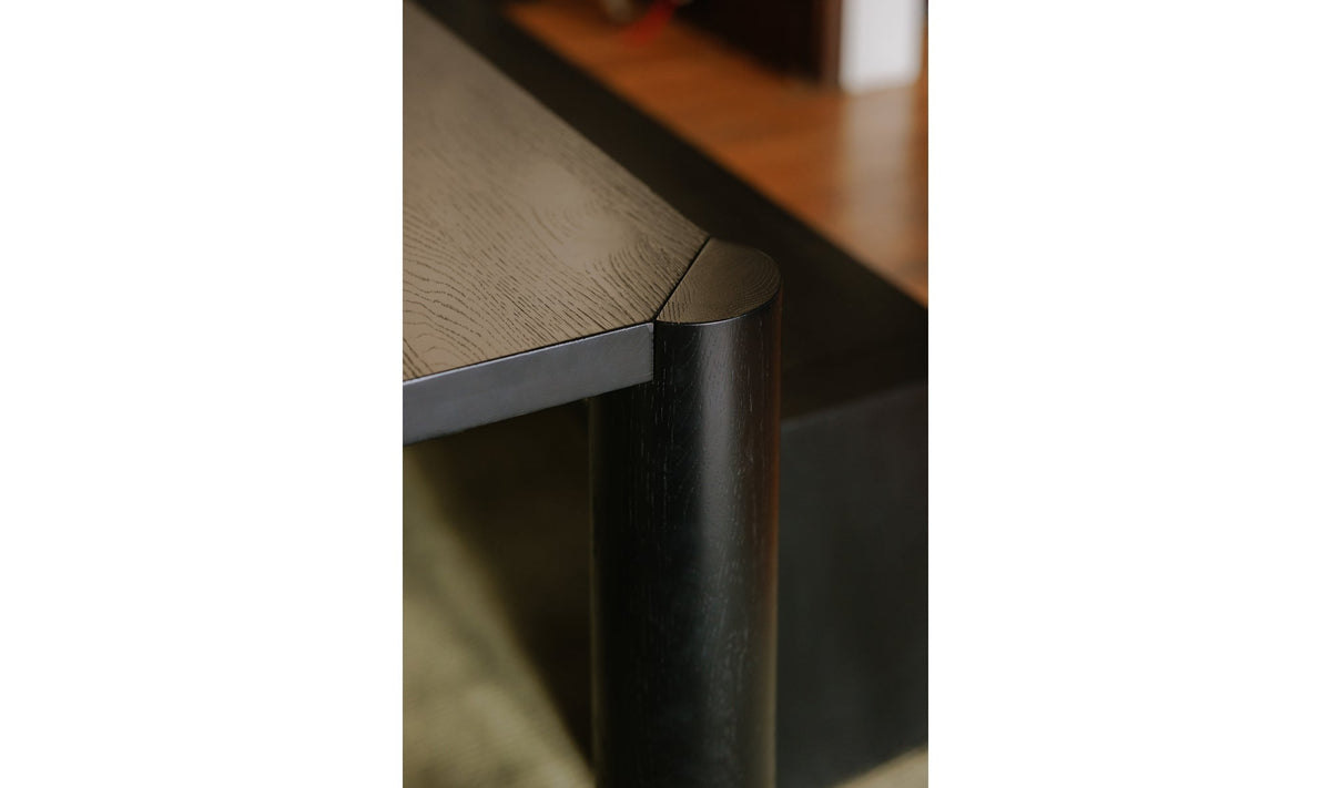 Détail d’un pied de table noire à angle arrondi et surface du plateau