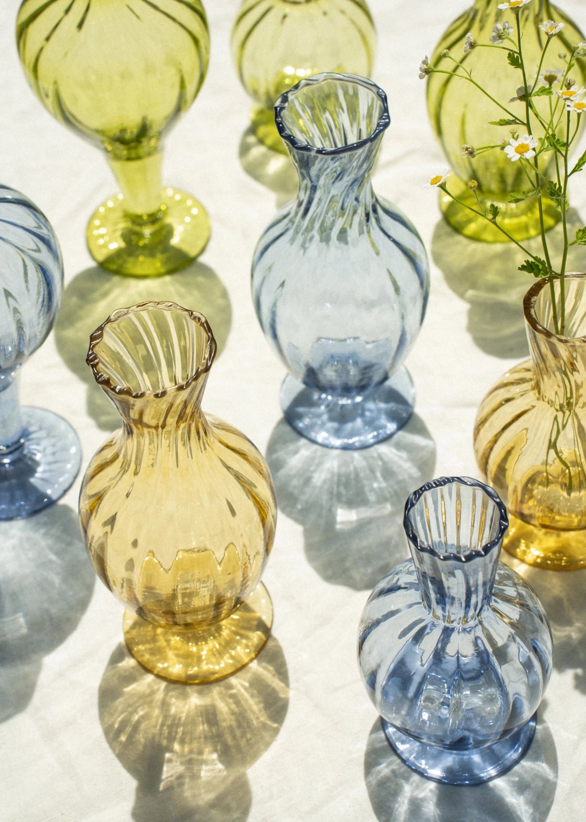 Vase en verre ambre soufflé à la main, forme bombée, rebord cannelé visible.