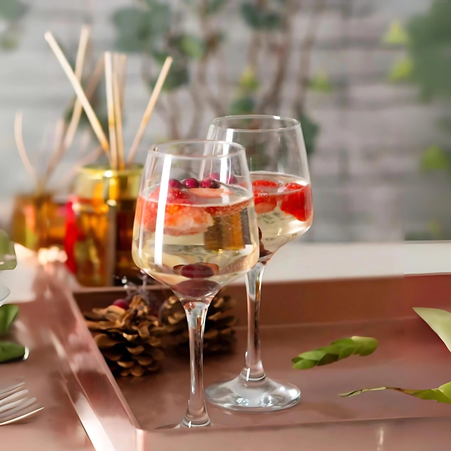 Deux verres à vin en verre transparent, pied évasé, avec vin rouge et fruits